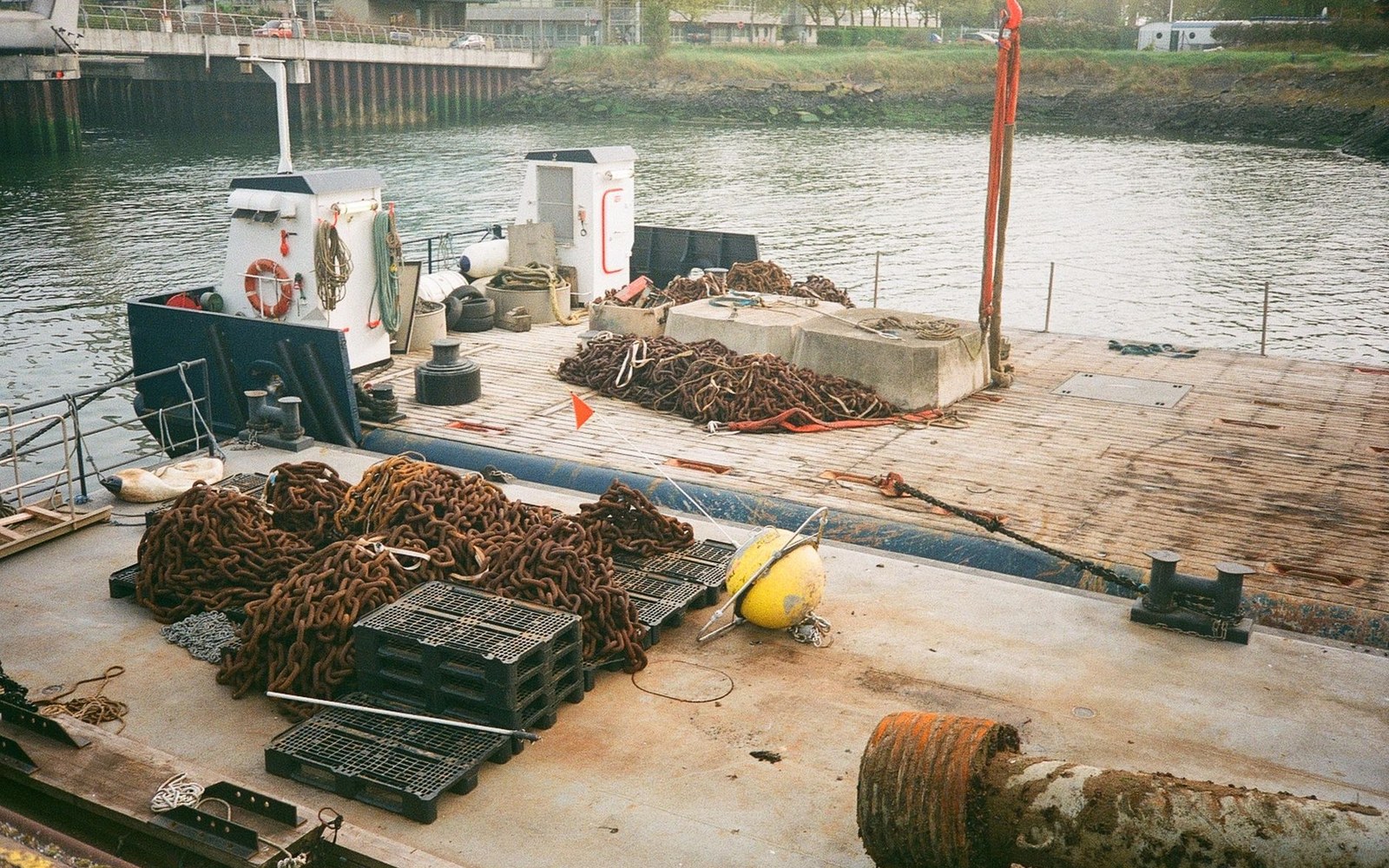 Heaps of mooring chain and a buoy stacked on a harbour pontoon